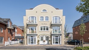 A multi-story building with a central entrance, balconies, and a sign reading "Frau Matthias". - Modern. Lichtdurchflutet. Wellness (Westerland)