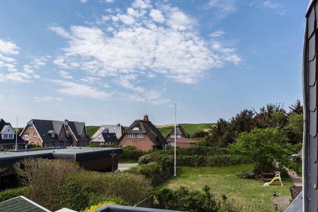 A residential area with houses, a grassy field, and a playground.
