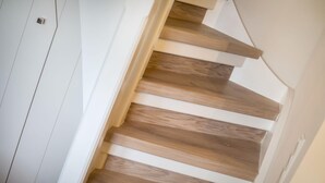 A staircase with wooden steps and white walls. - Hyggelig. Reet. Wellness. "dansk Hygge" im Witthüs, Whg. 10 Objekt-id: Wiw/10 (Wenningstedt)