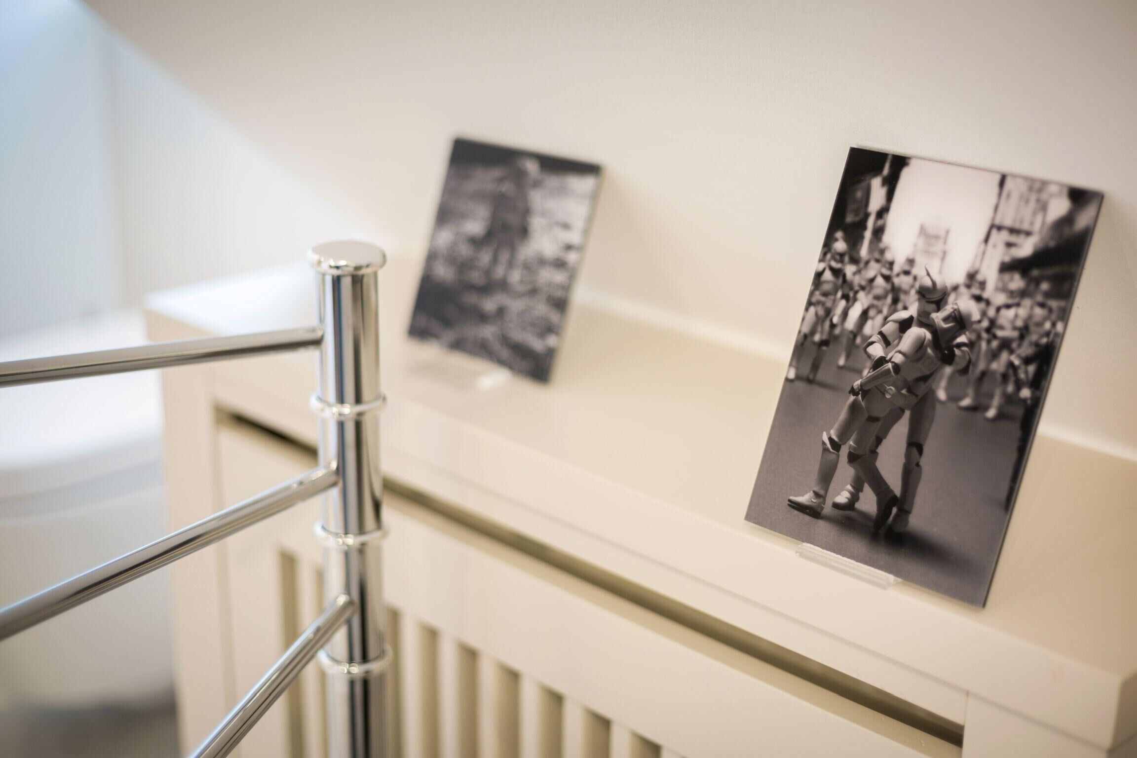 A photograph of a historical event displayed on a wall, with a metal railing in the foreground.
