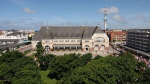 Ein großes, historisches Gebäude mit einem zentralen Rundbogenportal und zahlreichen Fenstern.