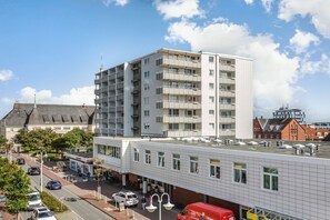 Un immeuble à plusieurs étages, doté d’un toit plat, de grandes fenêtres et d’une façade lisse.