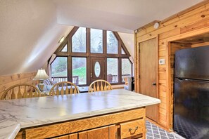 A kitchen with a marble countertop, wooden cabinets, and a black refrigerator. - Cozy Yatesville Lake Cabin Rental in Louisa! (Louisa)