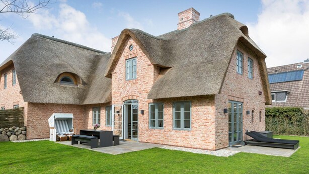 A brick house with thatched roofs and a well-maintained lawn. - Dansk Hus Sylt List (List)