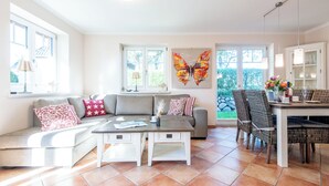 Un salon comprenant un canapé, une table basse et un coin repas avec des chaises et une table.