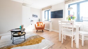 Una sala de estar moderna con comedor, chimenea y un ventanal grande.