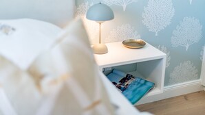 A bedroom with a bed, a bedside table with a lamp, and a shelf with a photo. - Stadthaus Boysenstraße, Whg. 7 Ruhig. Gemütlich. Strandnah. Objekt-id: Shb/07 (Westerland)