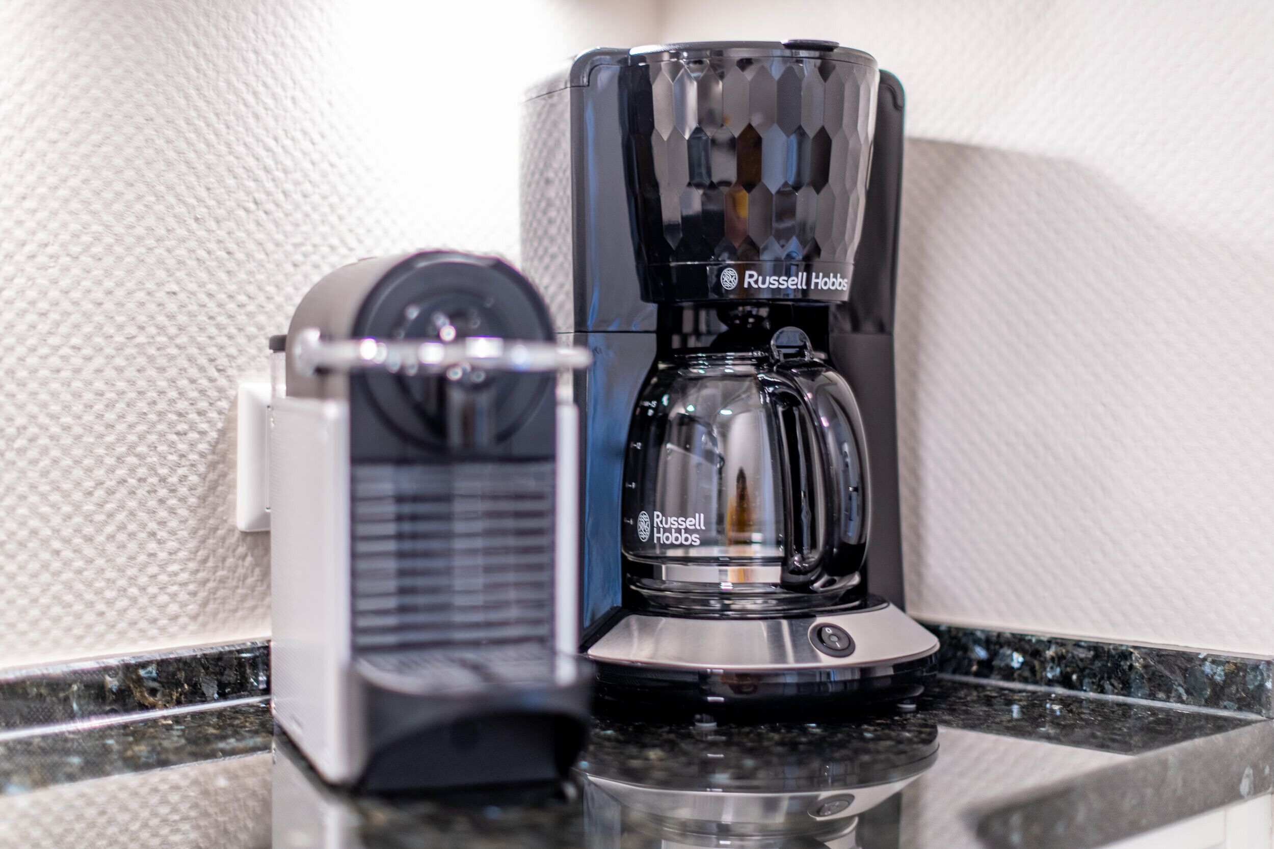 Eine Kaffeemaschine und eine Waage auf einer Arbeitsplatte.