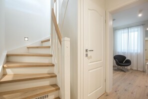 Un escalier avec des marches en bois menant à une porte blanche.