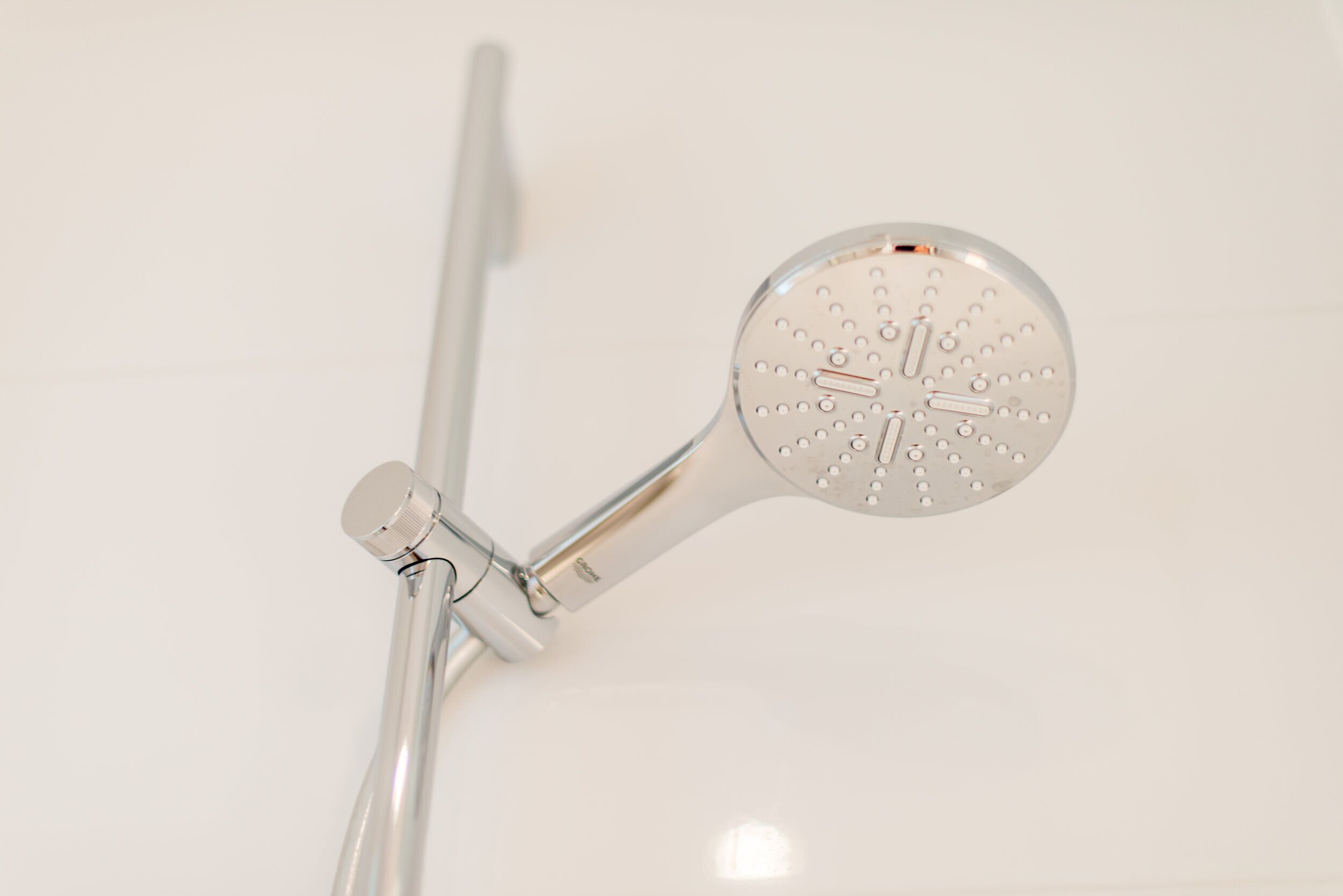 A modern showerhead with a circular design and multiple spray settings.