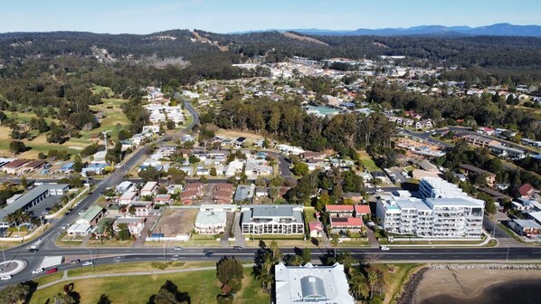 An aerial view of a residential area with houses, roads, and a large building with multiple floors.