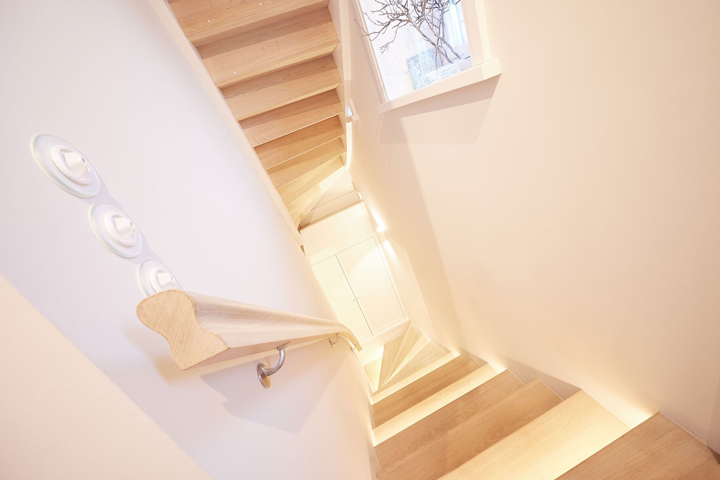Eine Treppe mit Holzbodenstufen und weißen Wänden.