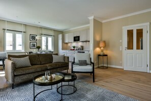 A living room with a sofa, armchairs, a coffee table, and a dining area with a table and chairs.