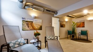 A spa area with reclining chairs, a sauna sign, and wall-mounted artwork. - Neubau. Strandnah. Anspruchsvoll. Objekt-id: Ljw/11 (Westerland)