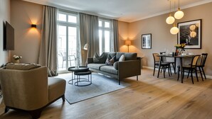 A modern living room with a sofa, armchair, and dining table set.