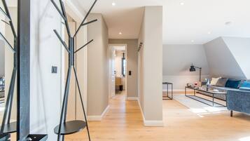 A modern living room with a sofa, coffee table, and a staircase leading to another level.