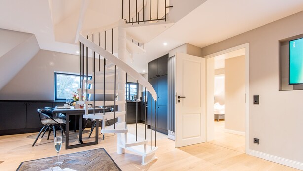 Un interior moderno con una escalera en espiral, un comedor y una cocina.