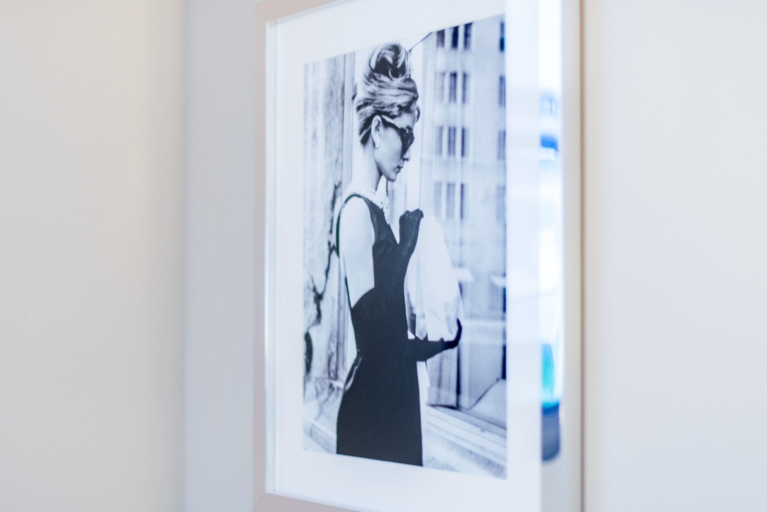 Une photographie en noir et blanc, encadrée, représentant une personne portant une robe, accrochée à un mur.