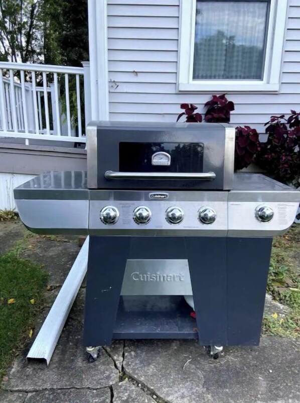 Un barbecue d’extérieur Cuisinart doté de quatre brûleurs, d’un panneau de commande et d’un thermomètre numérique.