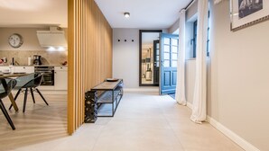 A modern kitchen with a dining area, a wooden partition, and a blue door leading to another room.