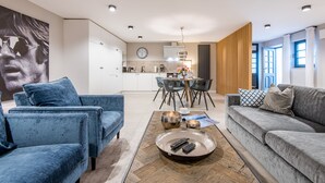 A modern living room with two sofas, a coffee table, and a dining area with chairs and a table.