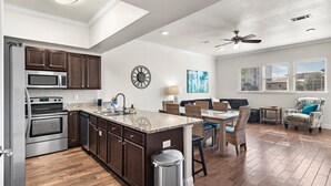 A modern kitchen with dark wood cabinets, stainless steel appliances, and a granite countertop. - 3BR • Walk to Beach • Free Beach Service🏖️  • Alerio C202 (Miramar Beach)