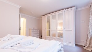 A bedroom with a bed, a wardrobe, and a bathroom visible through an open door.