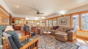 A spacious living room with a large sectional sofa, a wooden coffee table, and a patterned rug. - Cozy Lakefront Escape w/ Sauna, Swim Spa & Views (McHenry)