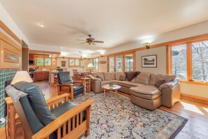 A spacious living room with a large sectional sofa, a wooden coffee table, and a patterned rug.