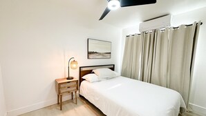 A bedroom with a bed, a nightstand, a ceiling fan, and a wall-mounted air conditioner. - New & updated 2-bedroom 1 bathroom apt. Near Modesto 1mile from HWY 99 (Salida)