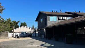 A two-story house with a garage, a covered driveway, and a fenced yard. - New & updated 2-bedroom 1 bathroom apt. Near Modesto 1mile from HWY 99 (Salida)