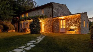A stone house with a stone pathway leading to the entrance, surrounded by greenery. - Anticiana 8, Emma Villas (Lucca)
