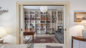 A cozy room with a large bookshelf, a desk, a sofa, and a patterned rug. - Villa Lucente 6+2, Emma Villas (Silvi Paese)