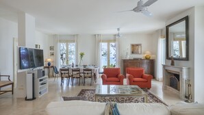 A spacious living room with a television, dining area, and fireplace. - Villa Lucente 6+2, Emma Villas (Silvi Paese)