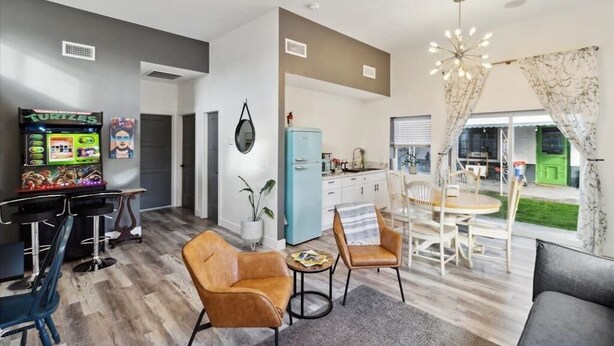 A modern living room with a gaming console, a dining area, and a kitchen. - The Gregory: 2 Bed/1 Bath Guesthouse (Phoenix)