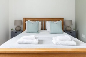 Cozy retreat with a central bed, two bedside tables, and a lamp on each.