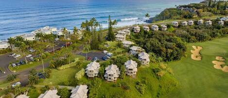 A coastal resort with beachfront villas, a golf course, and a parking area.