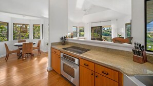 Una cucina moderna con una grande isola, mobili in legno e vista sull'esterno.