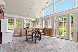 A covered patio with a table and chairs, a refrigerator, and a view of a backyard. - Casa Oasis - Large Home, 1-Acre, Near Trails & Fun (Springdale)