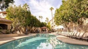 A swimming pool with lounge chairs, surrounded by palm trees and buildings. - Biltmore Retreat Resort-Style Heated Pool Spa Gym (Phoenix)