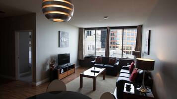 Departamento urbano, 2 camas Queen size | Área de sala de estar | Televisión de pantalla plana de 42 pulgadas con canales por cable