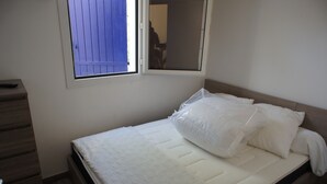 A single bed with white bedding in a room with a window and a wooden floor. - Charming air-conditioned house in Sorède sleeps 4/6, 6 km from Argelès Sur Mer. (Sorède)