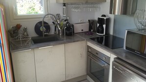 A compact kitchen with a sink, toaster, coffee maker, and oven. - Charming air-conditioned house in Sorède sleeps 4/6, 6 km from Argelès Sur Mer. (Sorède)