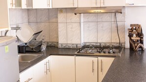 A kitchen with white cabinets, a black countertop, a stove, and a sink. - PRIVATE APART WITH AMAZING VIEW OF CUSCO (Cusco)
