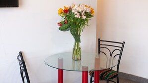 A round glass table with two chairs, one with a colorful cushion. - PRIVATE APART WITH AMAZING VIEW OF CUSCO (Cusco)