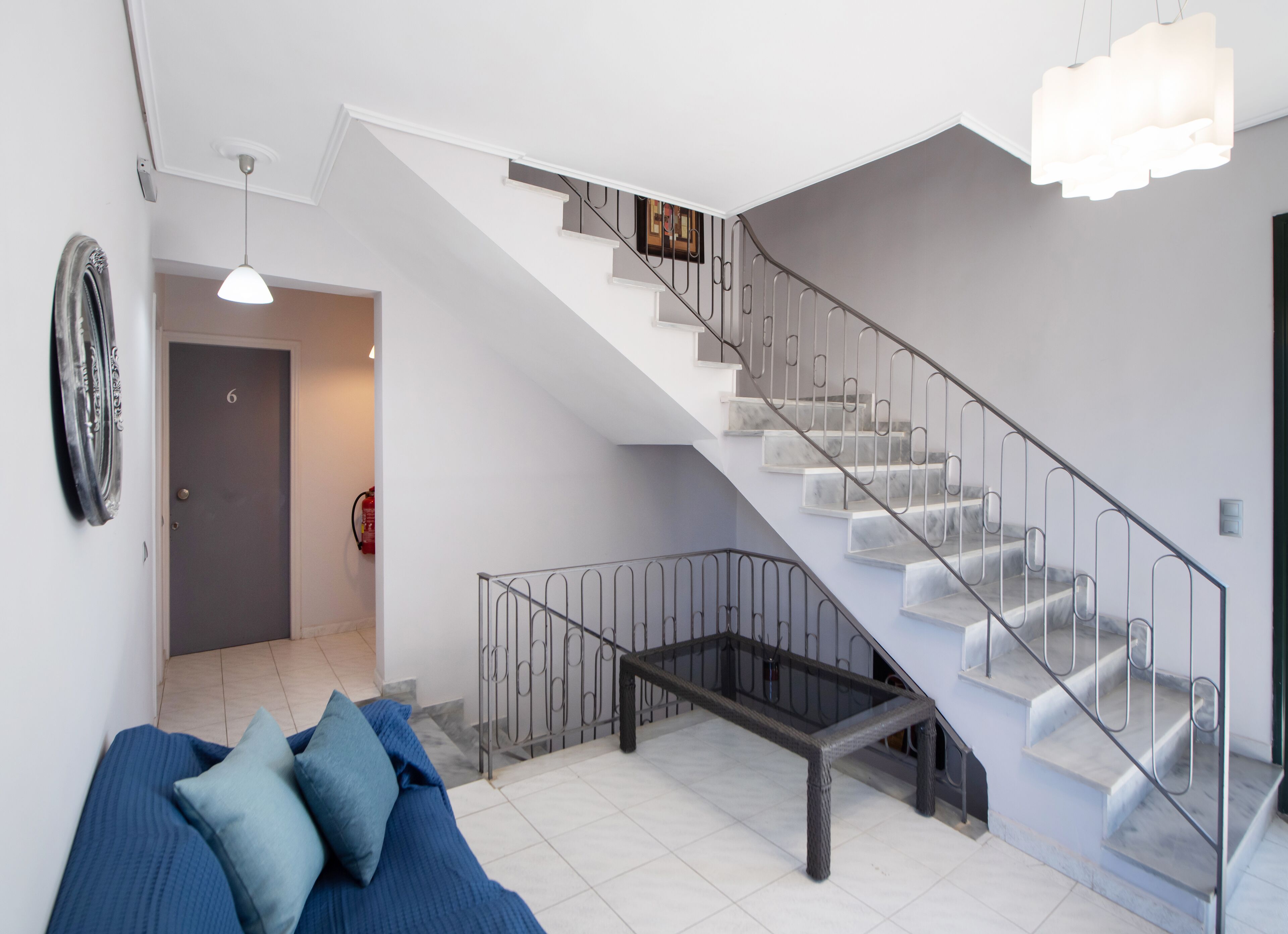 Ein modernes Interieur mit Treppe, einer Couch und einer Pendelleuchte.