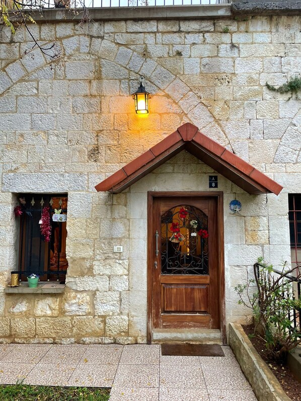 A stone building with a wooden door and a small window.