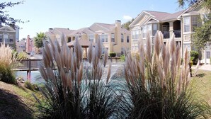 A residential area with multi-story houses, a small bridge, and a body of water. - Legacy Villa 1901 | Just a Short Walk to the Beach! (Gulfport)