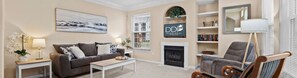 A cozy living room with a fireplace, a bookshelf, and a comfortable seating area.