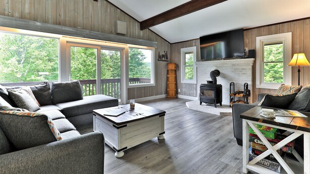 A cozy living room with a sectional sofa, a coffee table, and a fireplace. - Breakaway House by Killington Vacation Rentals (Killington)